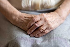 Older adult reviews a monthly care budget with a family member at a kitchen table.